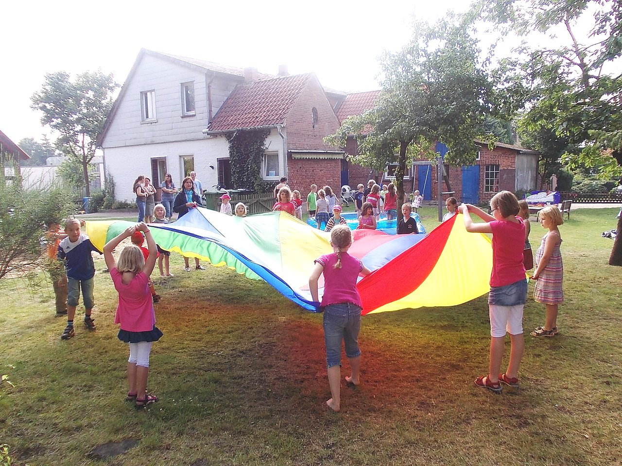 Foto von spielenden Kindern mit einer großen Stoffplane