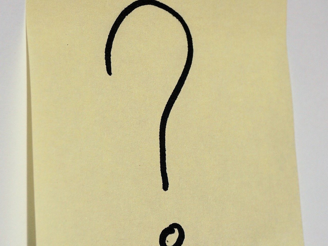 Das Bild zeigt ein hellgelbes Post-it mit einem schwarzen Fragezeichen darauf