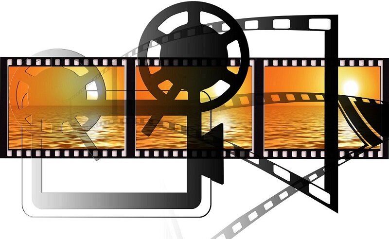 Zu sehen ist eine Kamera, Filmrolle und ein Sonnenuntergang