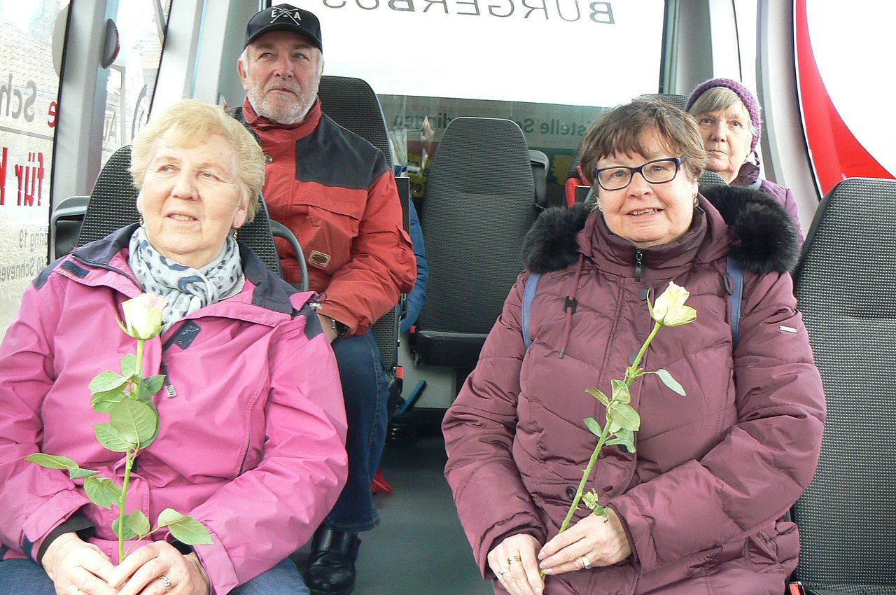 Foto von weiblichen Fahrgästen mit Rose am Weltfrauentag