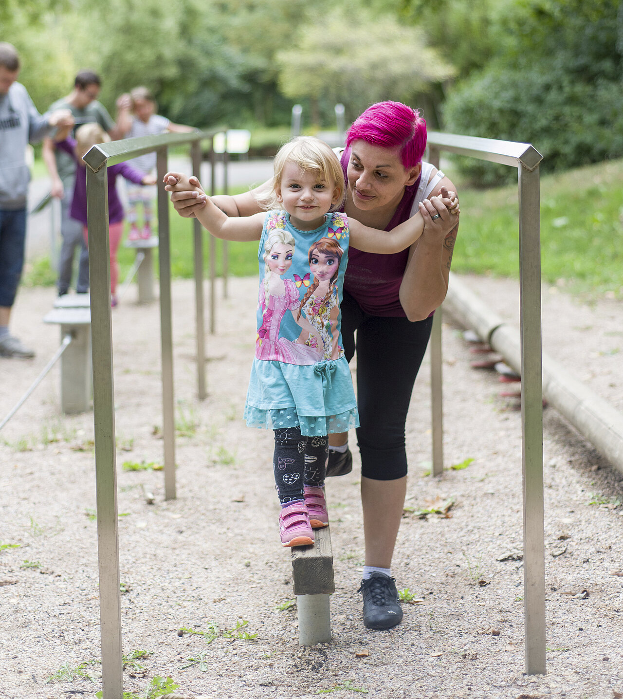 Da Foto zeigt eine Mutter, die ihr Kind beim Balancieren hält.